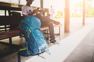 Traveler are backpacking and sitting alone at train station.