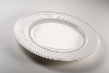 Empty round white plate on white table