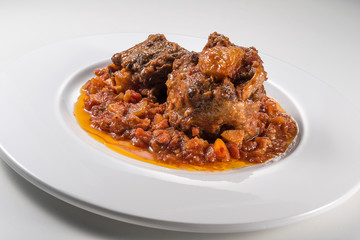 Isolated Dish with a portion of oxtail stewed vaccinara