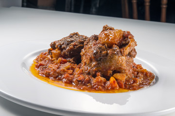 Isolated Dish with a portion of oxtail stewed vaccinara