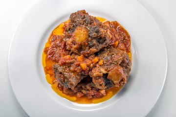 Isolated Dish with a portion of oxtail stewed vaccinara
