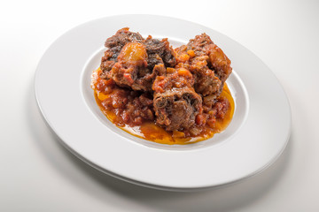 Isolated Dish with a portion of oxtail stewed vaccinara