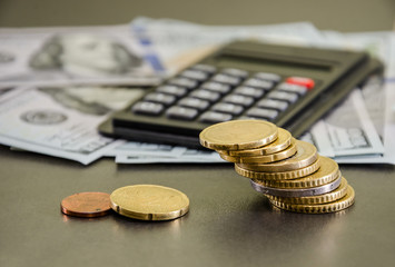 coins on the background of the calculator and dollars.