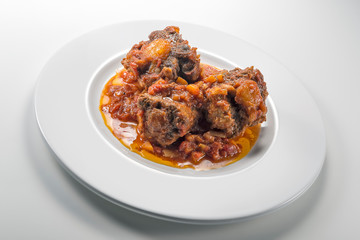 Isolated Dish with a portion of oxtail stewed vaccinara
