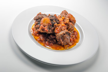 Isolated Dish with a portion of oxtail stewed vaccinara