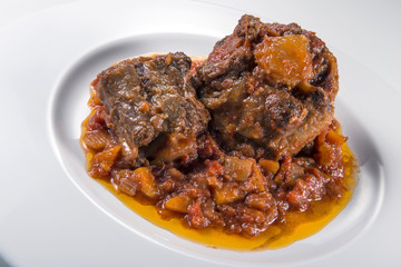 Isolated Dish with a portion of oxtail stewed vaccinara