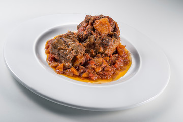 Isolated Dish with a portion of oxtail stewed vaccinara