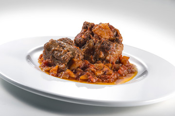 Isolated Dish with a portion of oxtail stewed vaccinara