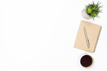 White minimalist office desk table with notebook, pen, cup of coffee and cactus pot. Top view with copy space, flat lay.