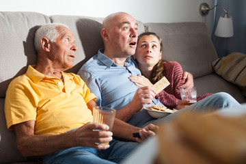 Family watching tv and drinking beer at home