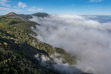 Nubes cubriendo montaña volcánica en isla