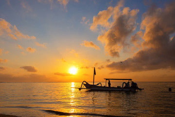 Travel in the morning sunrise in Bali, Indonesia. Traditional fishing boats at Sanur beach, Bali,...