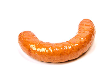 Grilled sausages with onions on a Board on a light background. Juicy sausage rings in a pile on a white background.