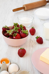 Strawberry pie ingredients: flour, eggs, milk, sugar, strawberry. Side view. Cooking strawberry pie or cake.
