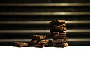 The concept of a profit graph made of chocolate cubes with white background for copy space.