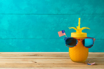 Happy Independence Day, 4th of July celebration concept with funny pineapple jar and sunglasses on wooden table - obrazy, fototapety, plakaty