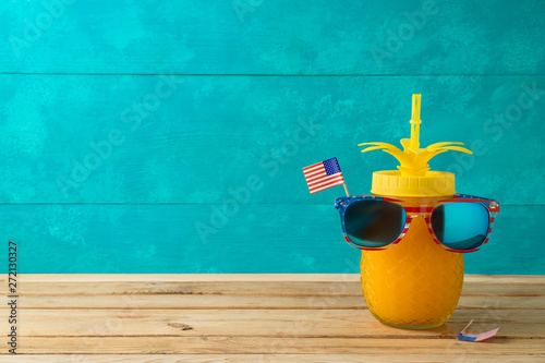 Happy Independence Day, 4th of July celebration concept with funny pineapple jar and sunglasses on wooden table