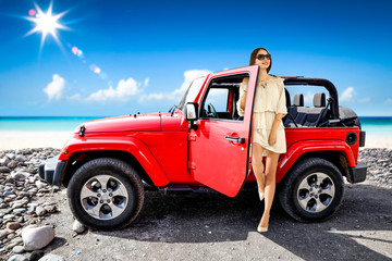 Fototapeta na wymiar Slim young woman and red summer car on beach. Free space for your decoration and sunny day. 