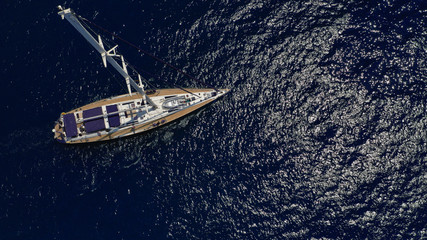 Fototapeta premium Aerial drone top view photo of sail boat sailing in mediterranean Aegean island of Santorini, Cyclades, Greece