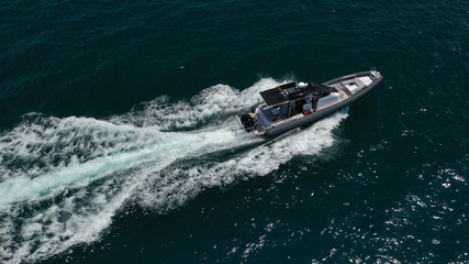 Aerial top view luxury inflatable rib speed boat cruising in Aegean deep blue open sea