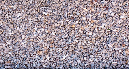 Grey ground stone rubble background of many small stones