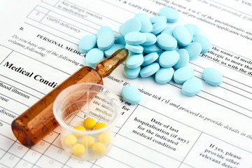 Brown ampoule and colorful pills on medical questionnaire form