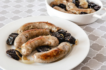 White sausage fried with onions and dried plums.