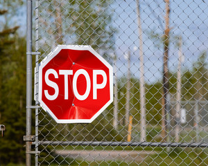 Stop sign on metal gate.