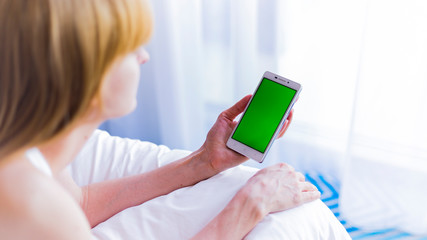 The smartphone in the hands of a young woman 