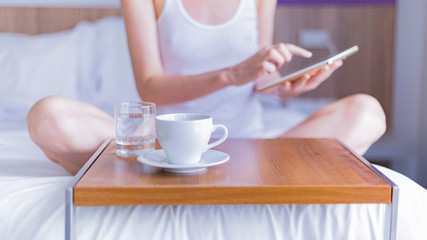 woman with cup of coffee using tablet