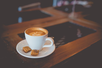 Latte hot coffee with foam milk art on a wooden table