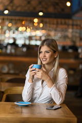 Happy woman enjoying in a cup of coffee and day dreaming