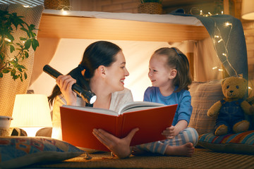 mother and daughter playing in tent