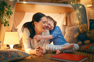 mother and daughter playing in tent
