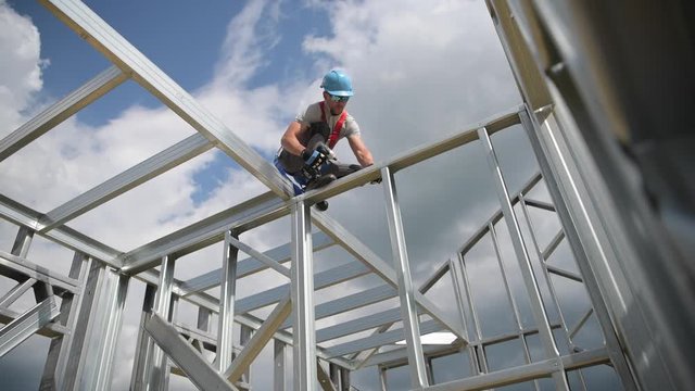 Safety Harness Equipment. Caucasian Contractor in His 30s on a Steel Building Frame. Working At Height Concept.