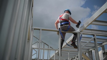 Shock Absorbing Lanyard and Safety Harness Equipment. Work at Height Safety. Caucasian Contractor on a Steel Building Frame.