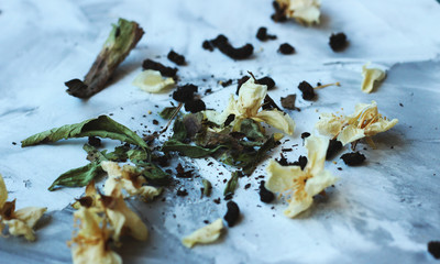 dried jasmine flovers and green tea on a grey background close