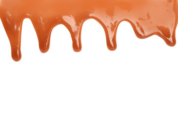 Delicious caramel sauce flowing on white background