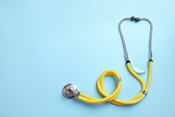 Stethoscope with space for text on color background, top view. Medical tool