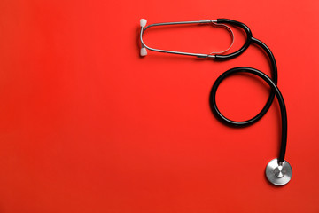 Stethoscope with space for text on color background, top view. Medical tool