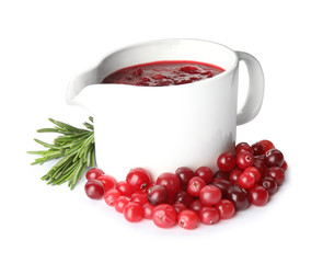 Pitcher of cranberry sauce with rosemary on white background
