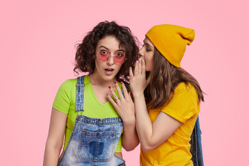 Young girl gossiping with friend