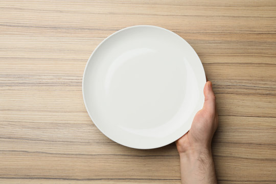 Man With Empty Plate At Wooden Table, Top View