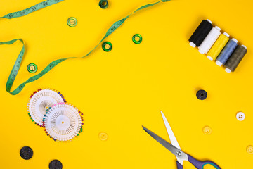 Sewing accessories with space for text on yellow background. Top view
