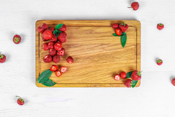 Top view of board with place for text with strawberries and mint on white background