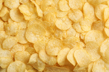 Crispy potato chips as background, top view