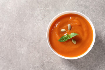 Bowl of tasty sweet potato soup on grey background, top view. Space for text
