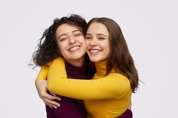 Best friends hugging and cheerfully smiling