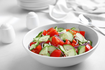 Delicious fresh cucumber tomato salad in bowl on table