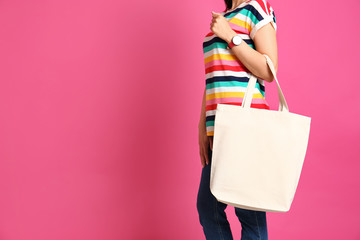 Woman with stylish blank eco bag against color background, closeup. Space for text